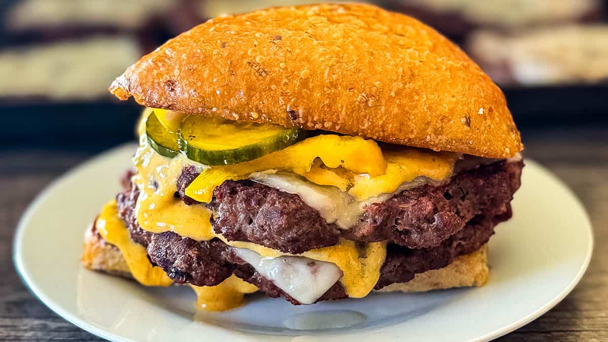 Double smash burger made with ground venison, topped with melted cheese, pickles, and special sauce on a toasted bun.