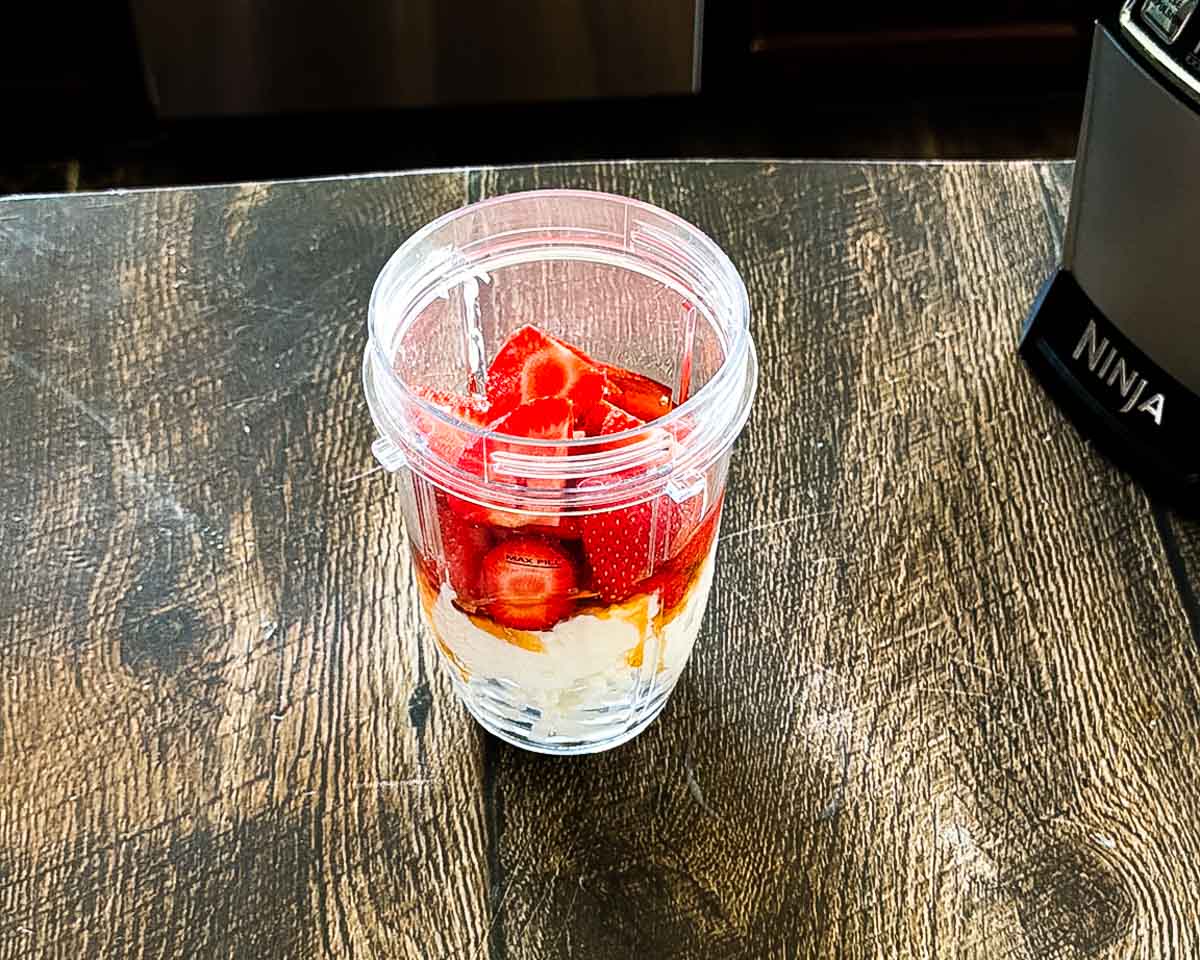 Ingredients for the strawberry cottage cheese ice cream in a blender.
