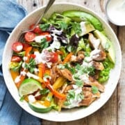 Chicken fajita salad in a white serving bowl.