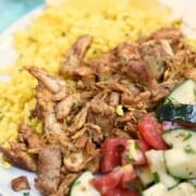 Instant pot chicken shawarma on a plate with rice and vegetables.