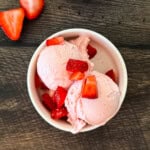 Creamy Ninja Creami strawberry cottage cheese ice cream made with cottage cheese and fresh strawberries in a white bowl.
