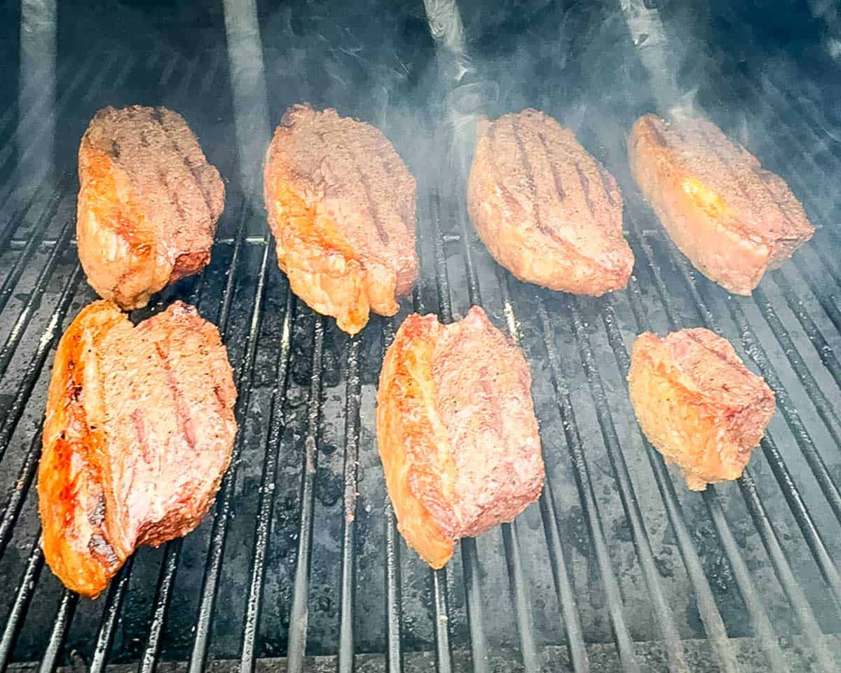 Smoked picanha steaks being reverse seared on a pellet grill for a crispy crust.