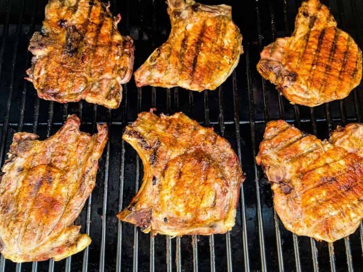 Smoked pork chops on the grill grate of a pellet grill.