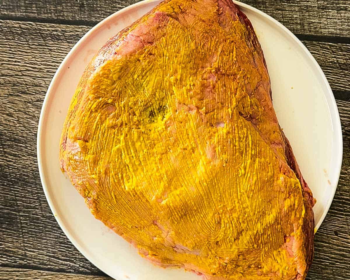 Roast coated with mustard to help the seasoning stick.
