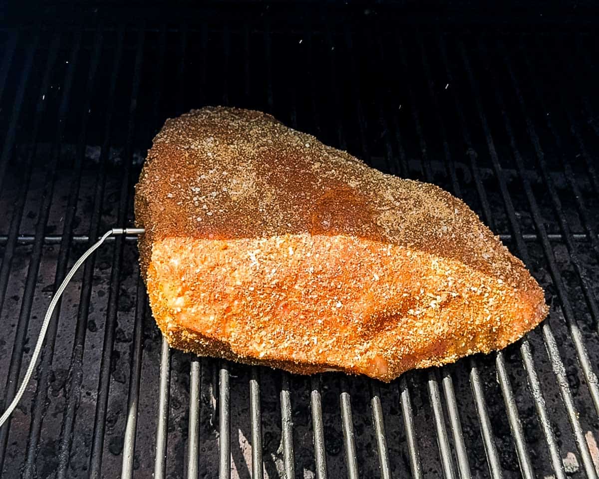 The seasoned roast on my Pit Boss pellet grill with a temperature probe inserted.