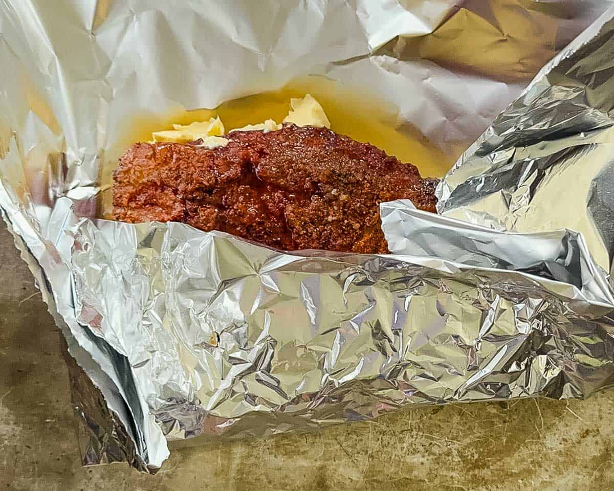 Smoked tri-tip wrapped in foil with beef broth and butter before returning it to the smoker.