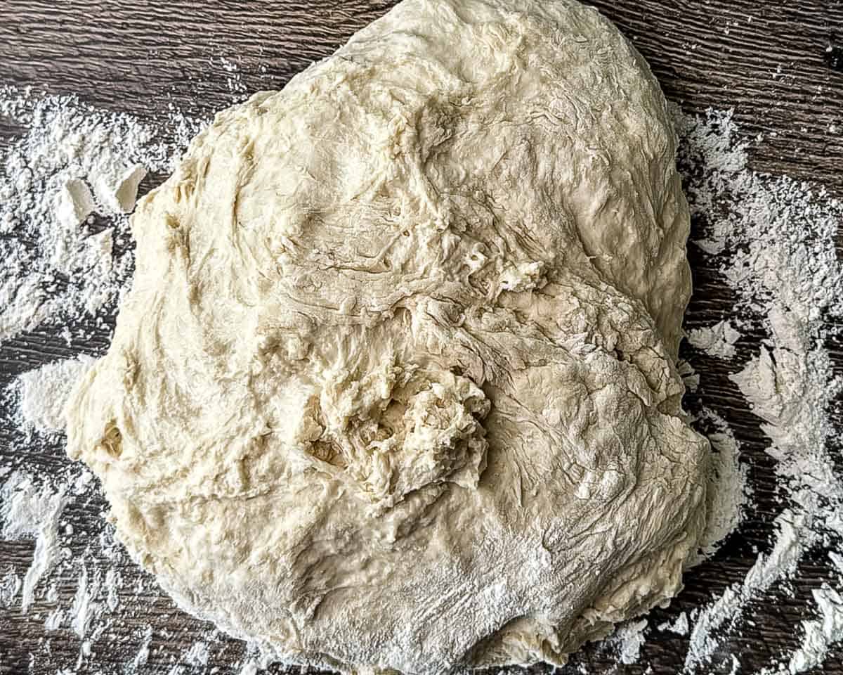 Sourdough discard hamburger bun dough turned out onto a floured surface.