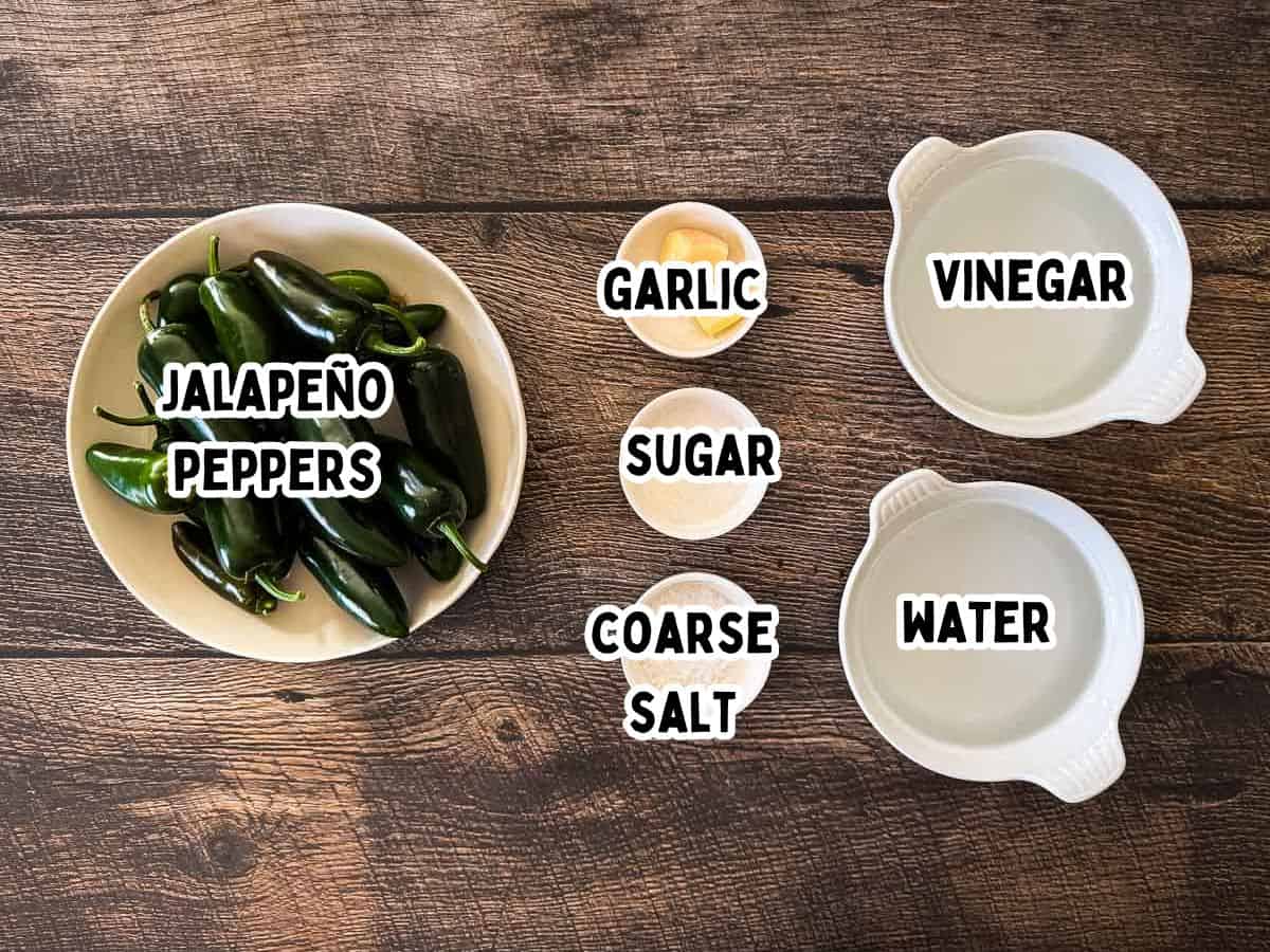 Fresh jalapeño peppers, garlic, white vinegar, water, sugar, and coarse salt for homemade canned jalapeño peppers.