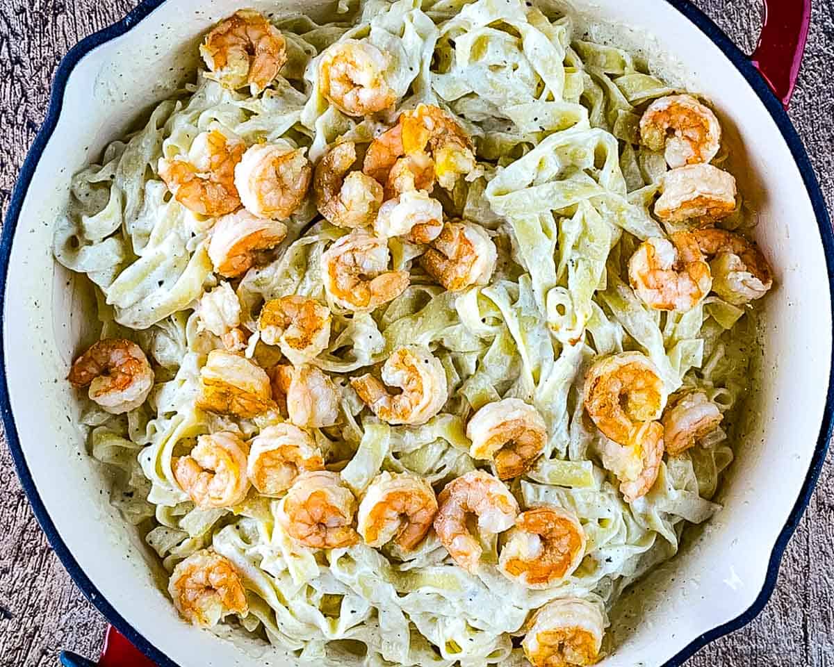 Cooked shrimp added to fettuccine coated in creamy Alfredo sauce.