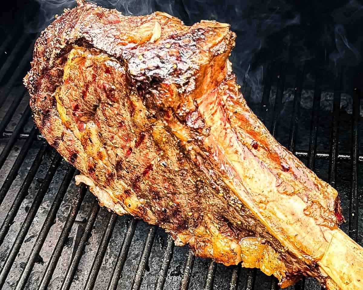 Tomahawk steaks reverse searing on a hot pellet grill.