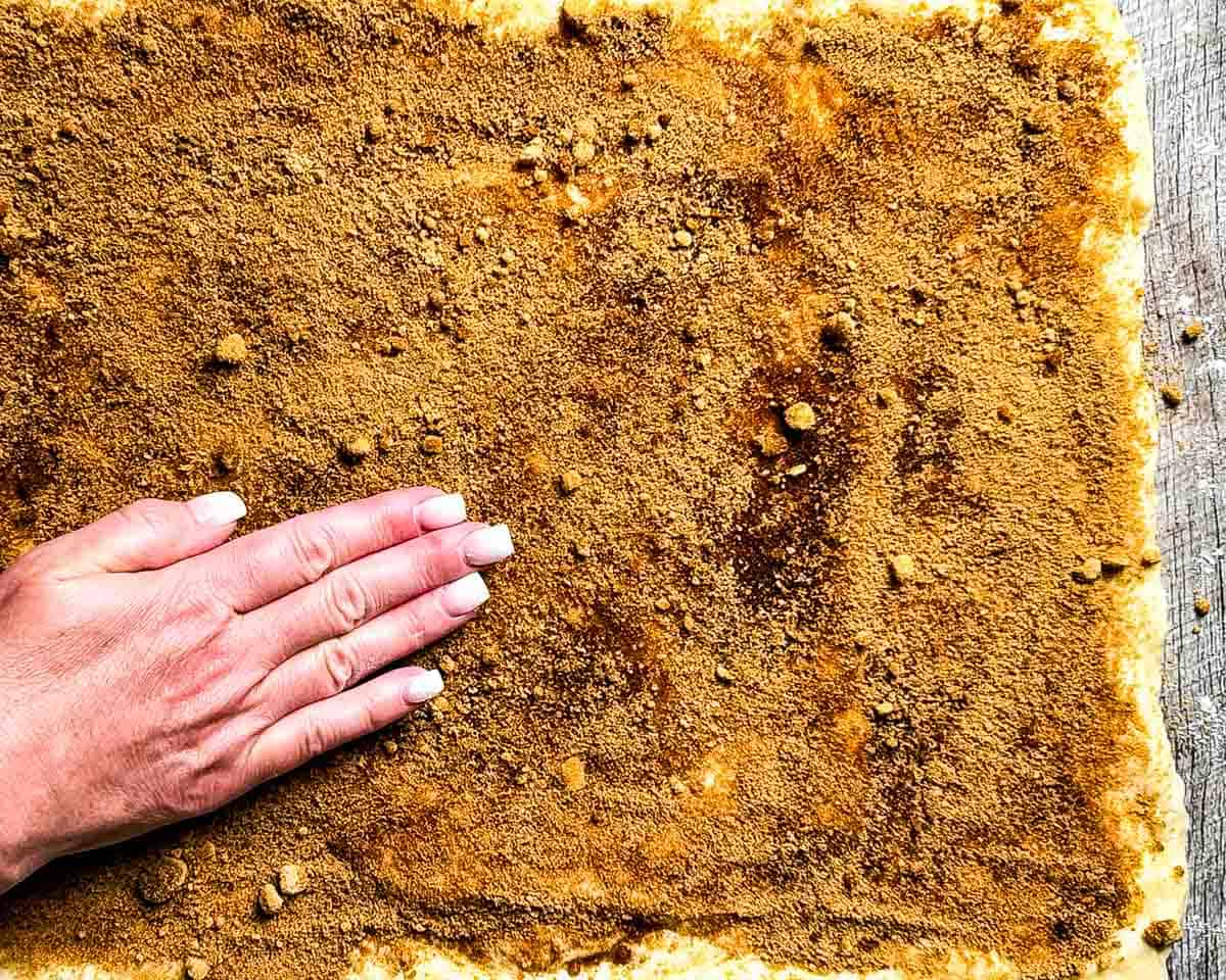 Sprinkling brown sugar filling on dough.