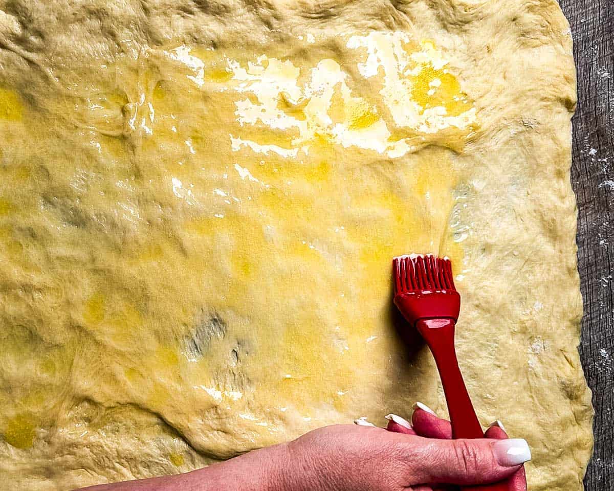Brushing dough with melted butter.