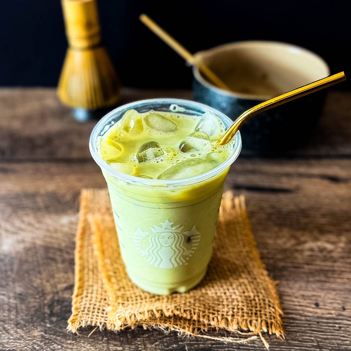 Starbucks iced matcha latte with milk, matcha, ice, and a gold straw.