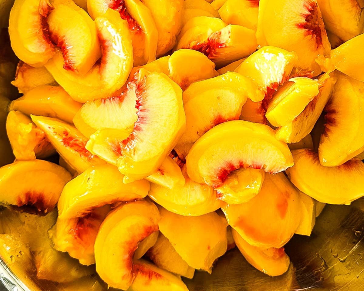 Peeled yellow peaches cut into pieces for canning.