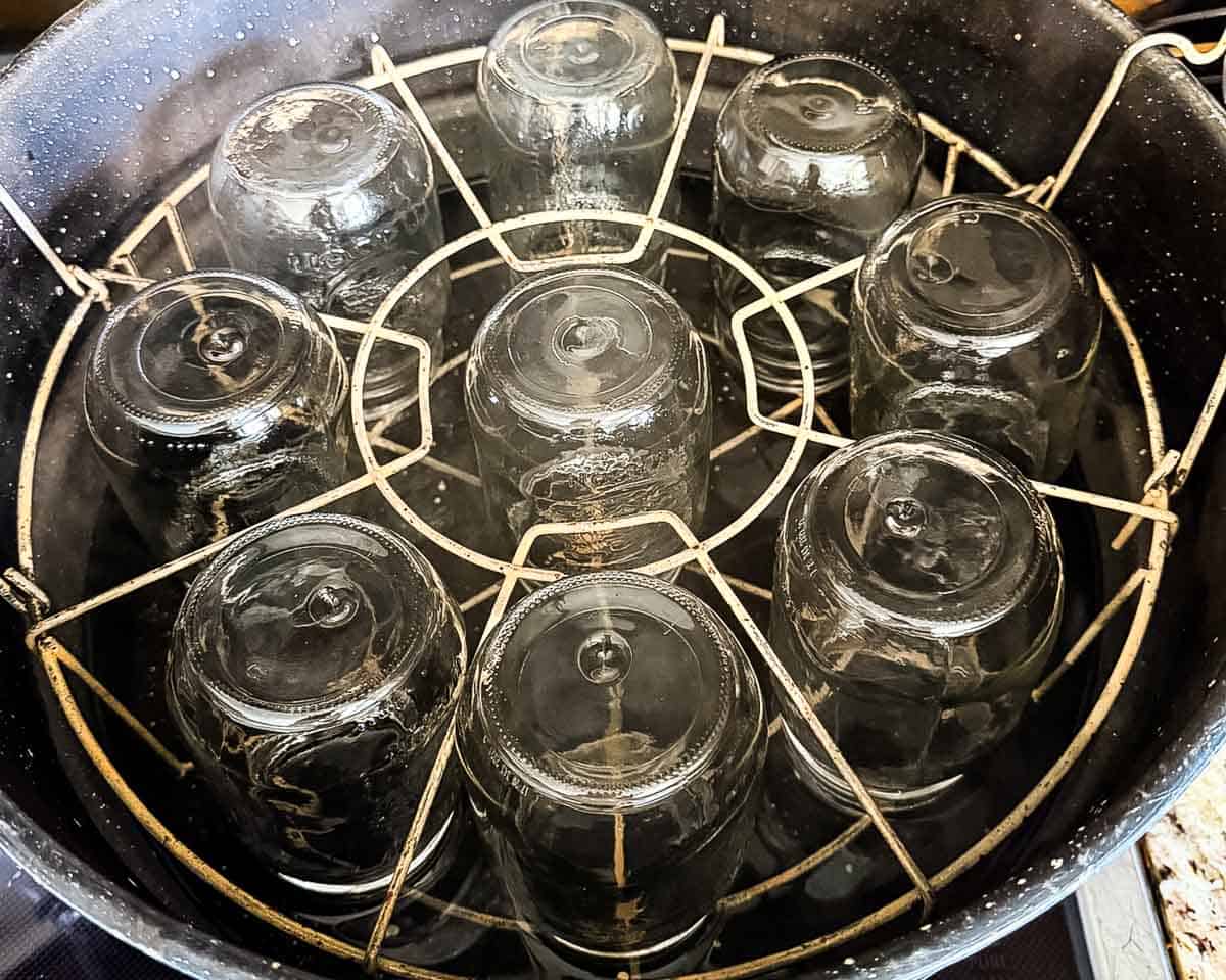 Pint canning jars heating in a water bath canner.