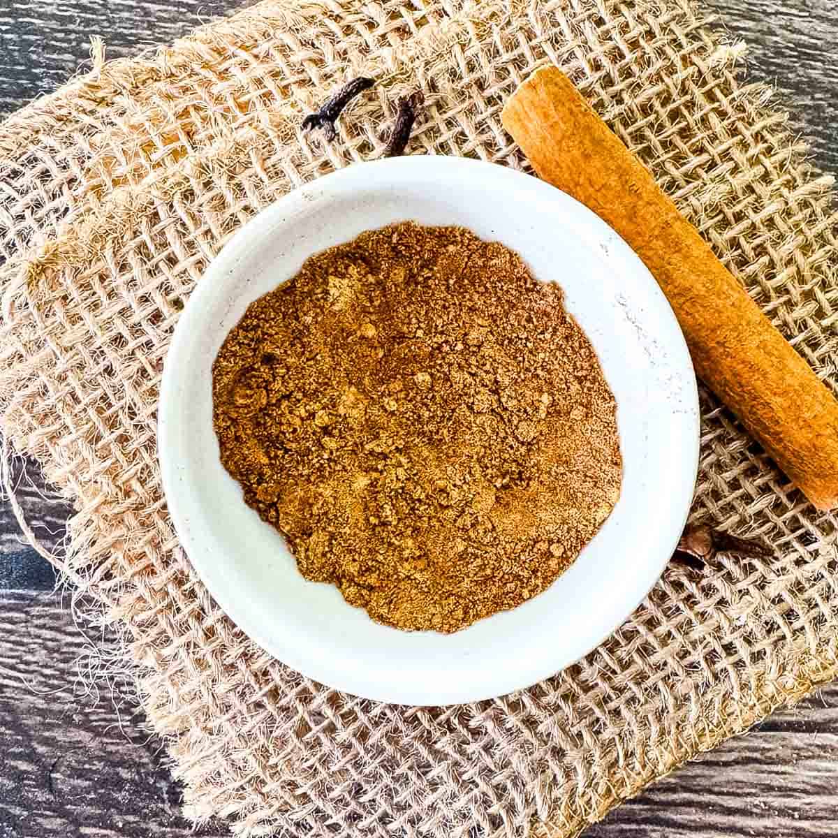 Homemade pumpkin pie spice ready to use in a small white bowl.