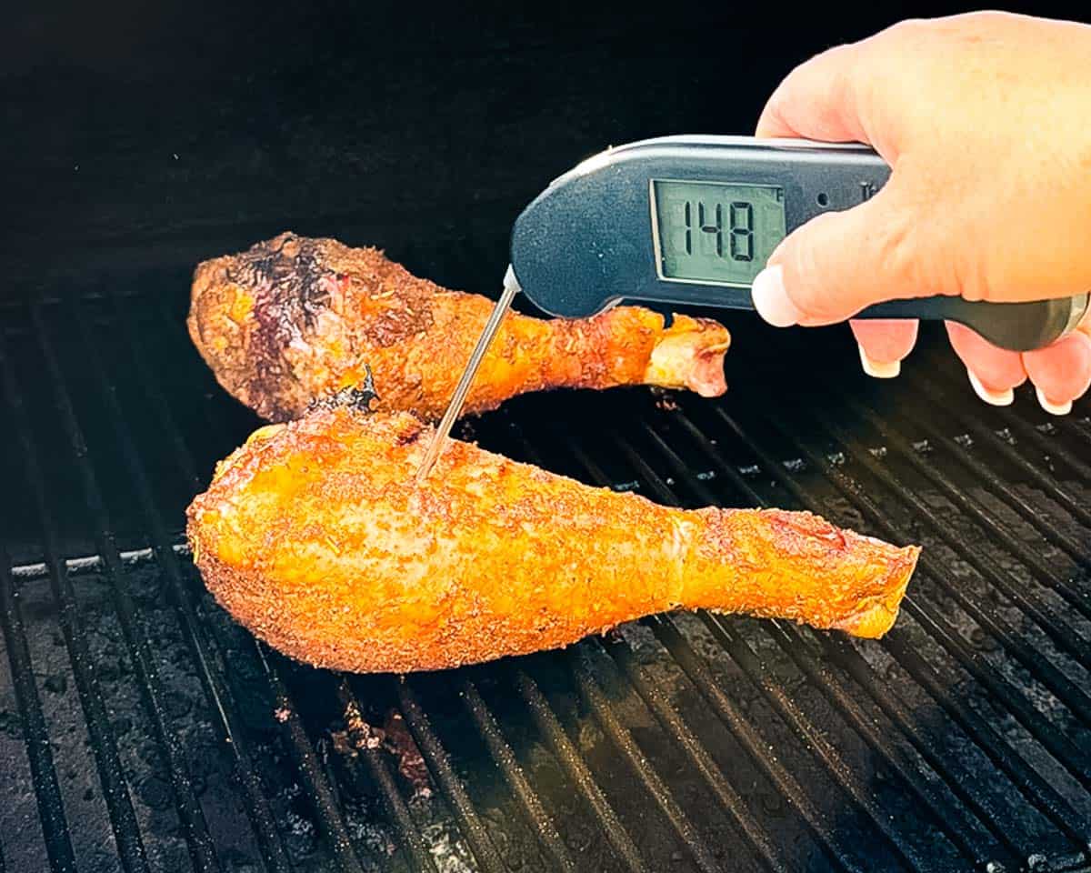 Checking the internal temperature of a turkey leg with a meat thermometer.