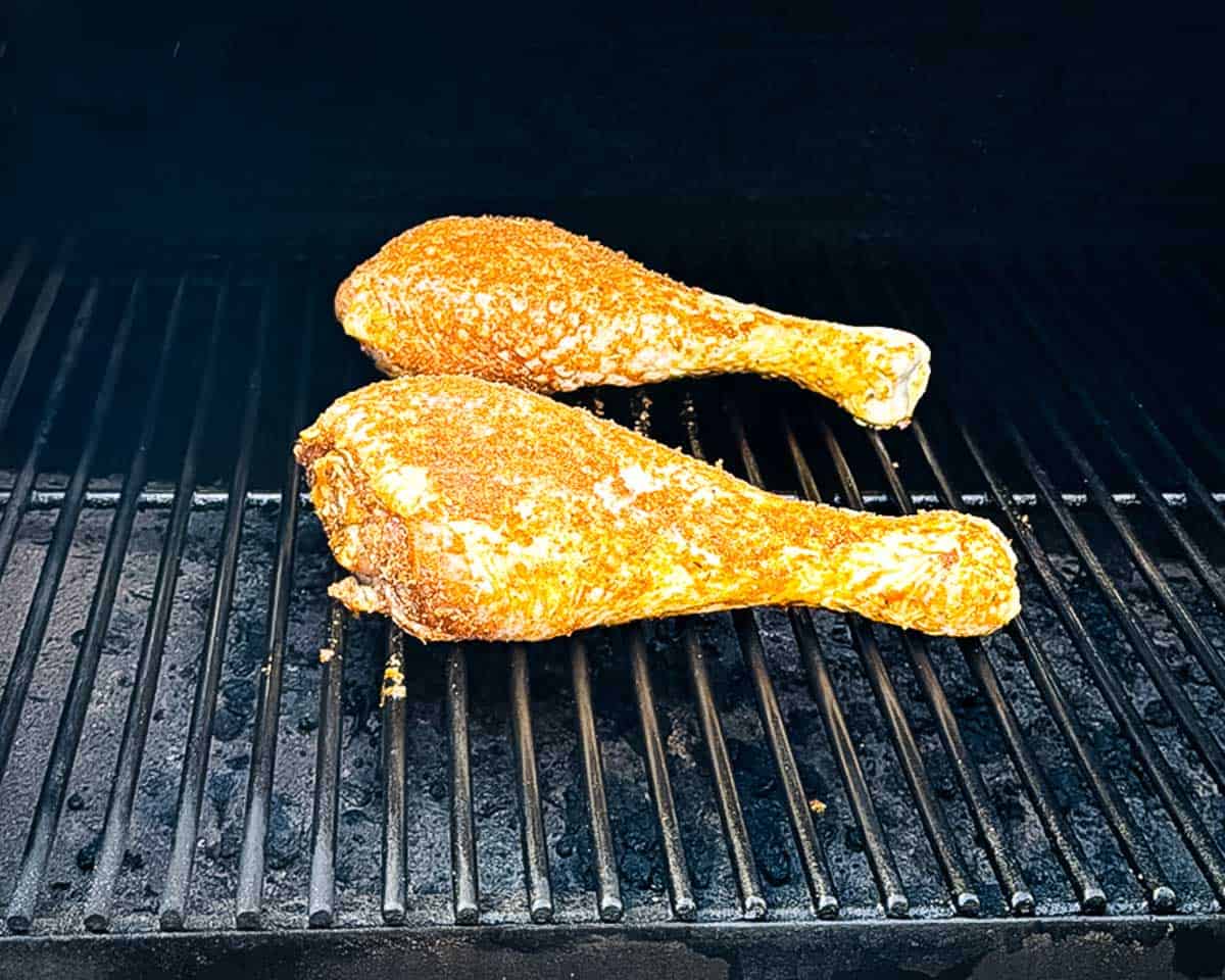 Seasoned turkey legs placed directly on the pellet grill grates.