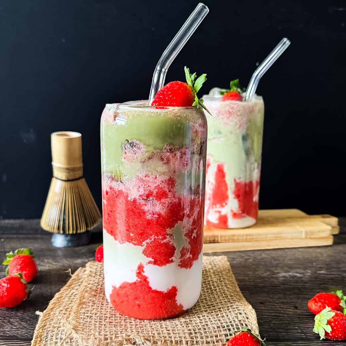 Iced strawberry matcha latte layered with strawberry puree, milk, and matcha.
