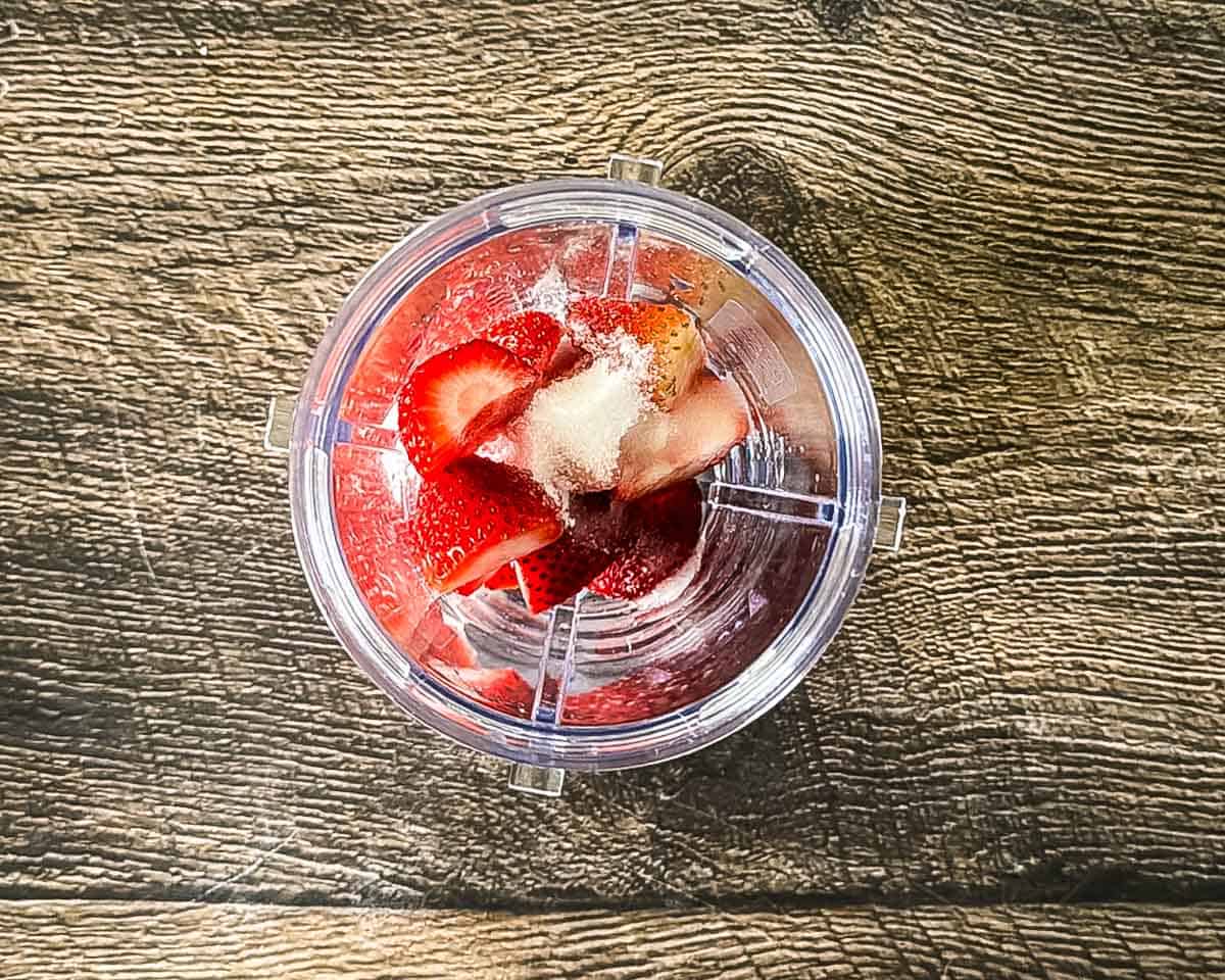 Fresh strawberries, sugar, and lemon juice in a blender for strawberry puree.