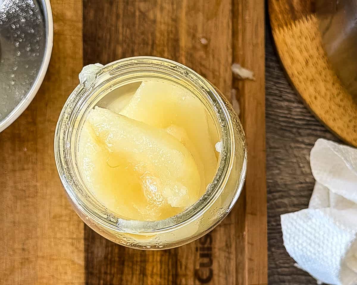 Hot pear halves packed into a pint canning jar.