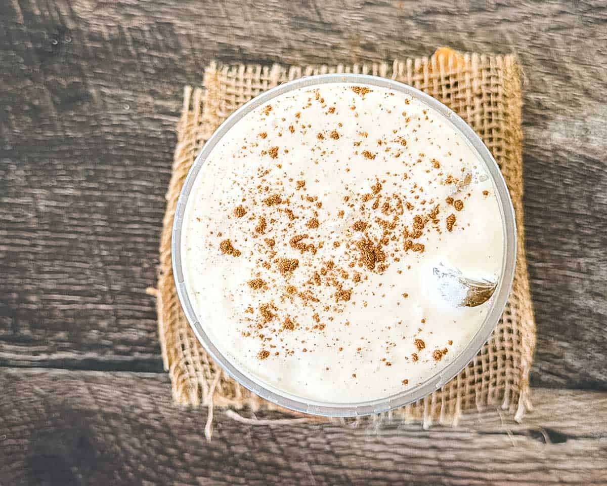 Pumpkin cream chai latte topped with cold foam and a sprinkle of pumpkin pie spice, seen from above.