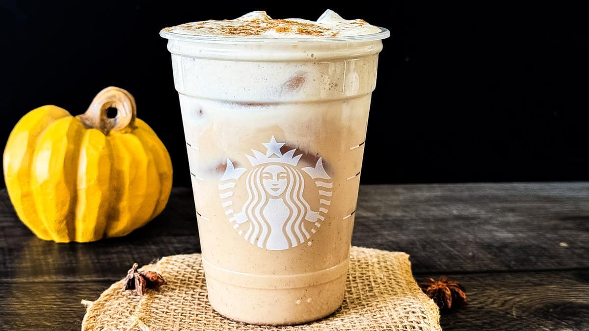 Iced pumpkin cream chai latte topped with pumpkin cold foam in a reused Starbucks glass.