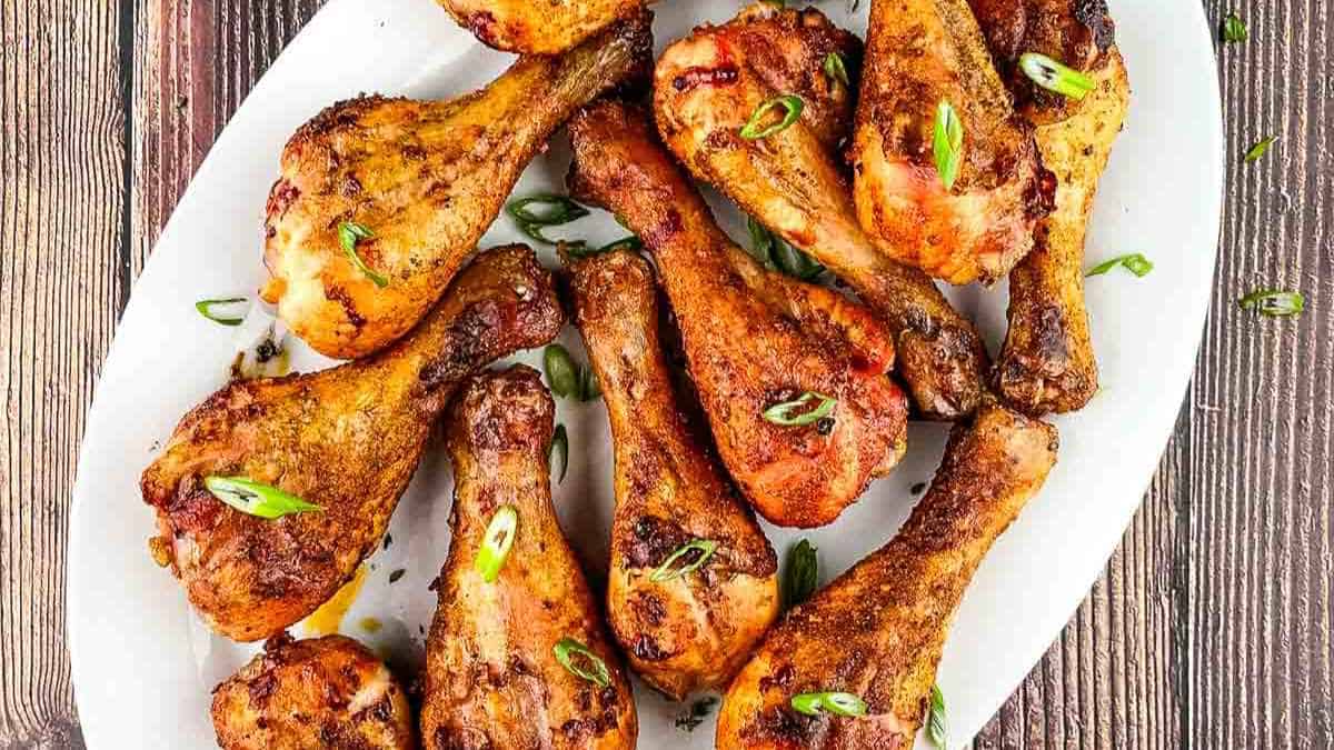 Smoked chicken legs on a white serving dish.