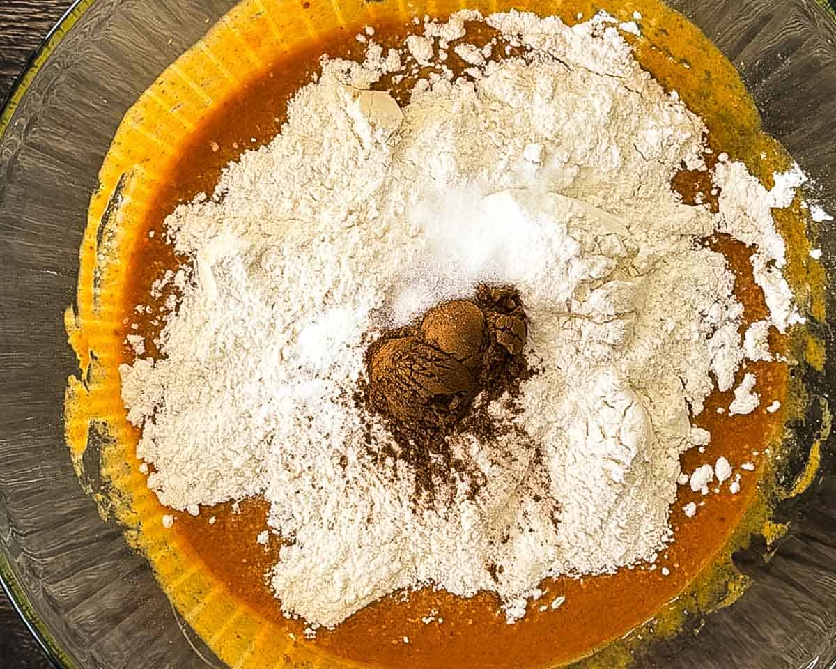 Flour, baking soda, baking powder, and pumpkin pie spice added to the wet pumpkin bread ingredients.
